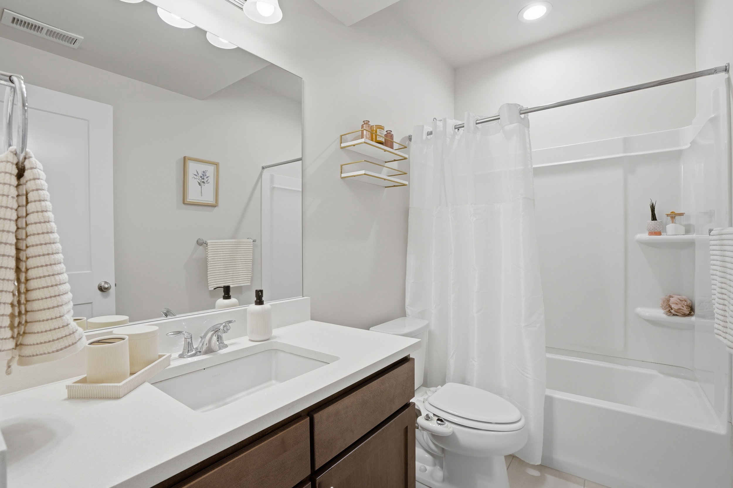 Bathroom with vanity, shower / bath combo, and light tile patterned floors