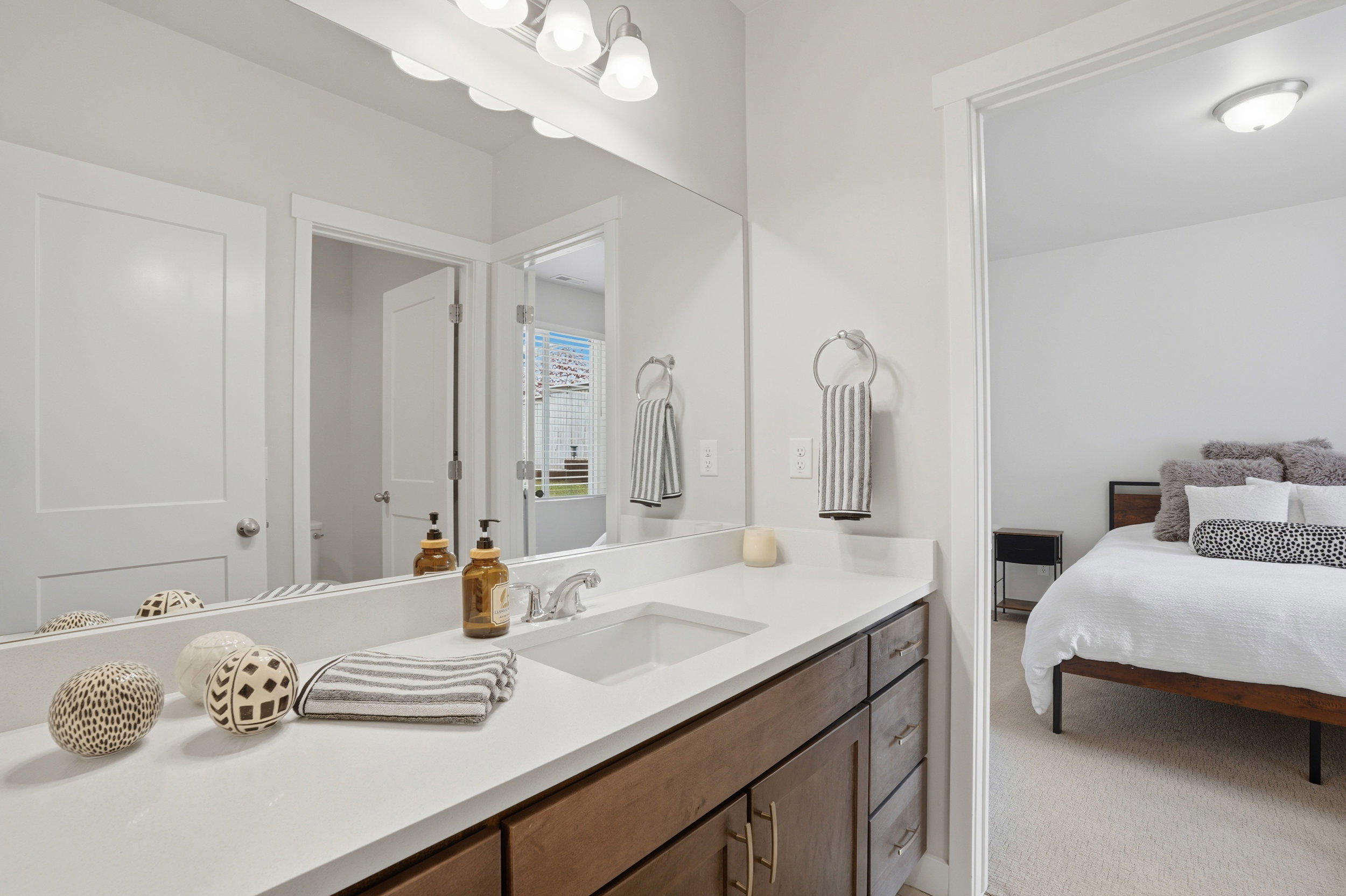 Ensuite bathroom featuring vanity and light colored carpet