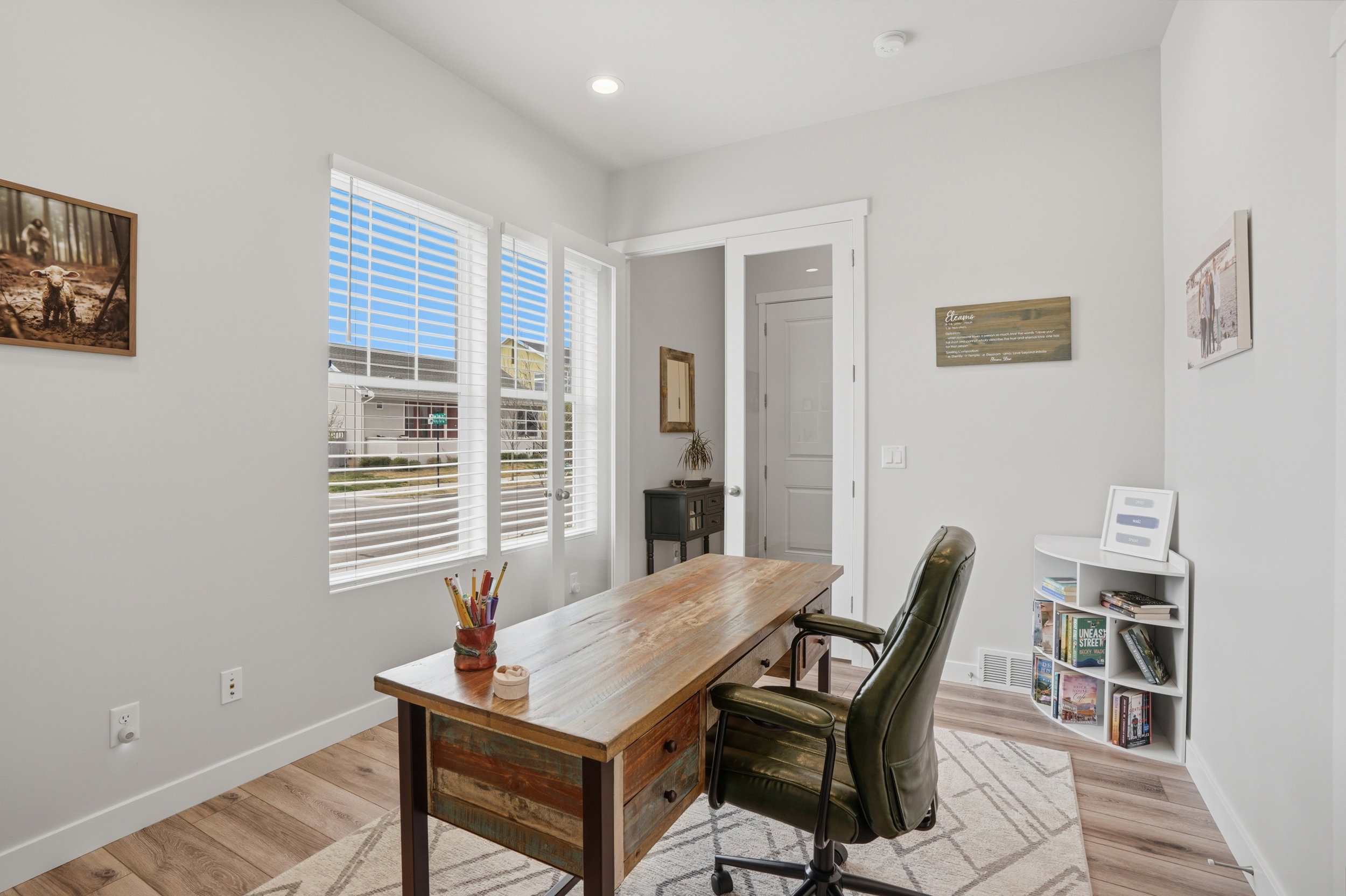 Office with light wood-type flooring and recessed lighting