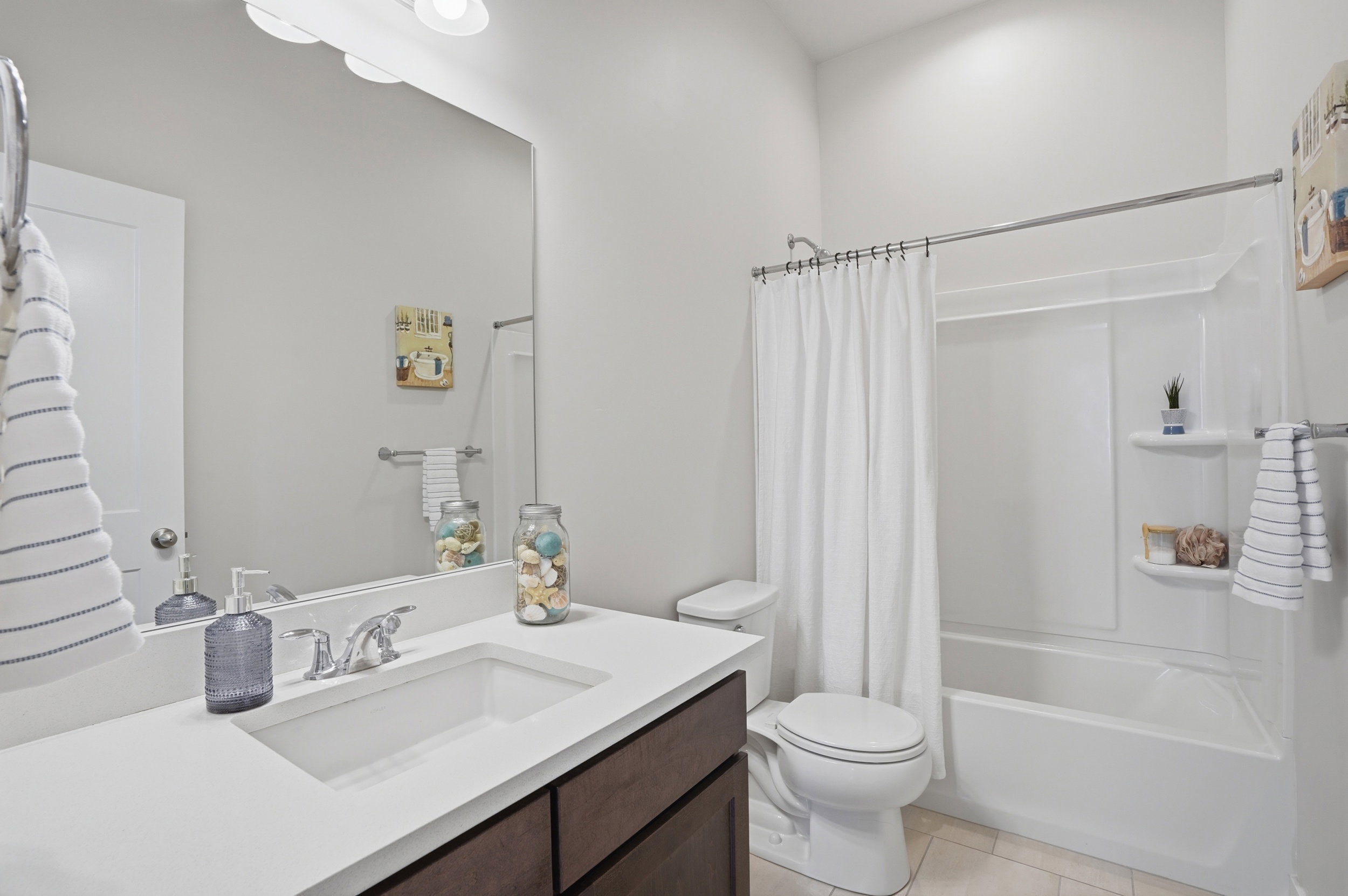 Bathroom featuring vanity, shower / tub combo with curtain, and light tile patterned floors