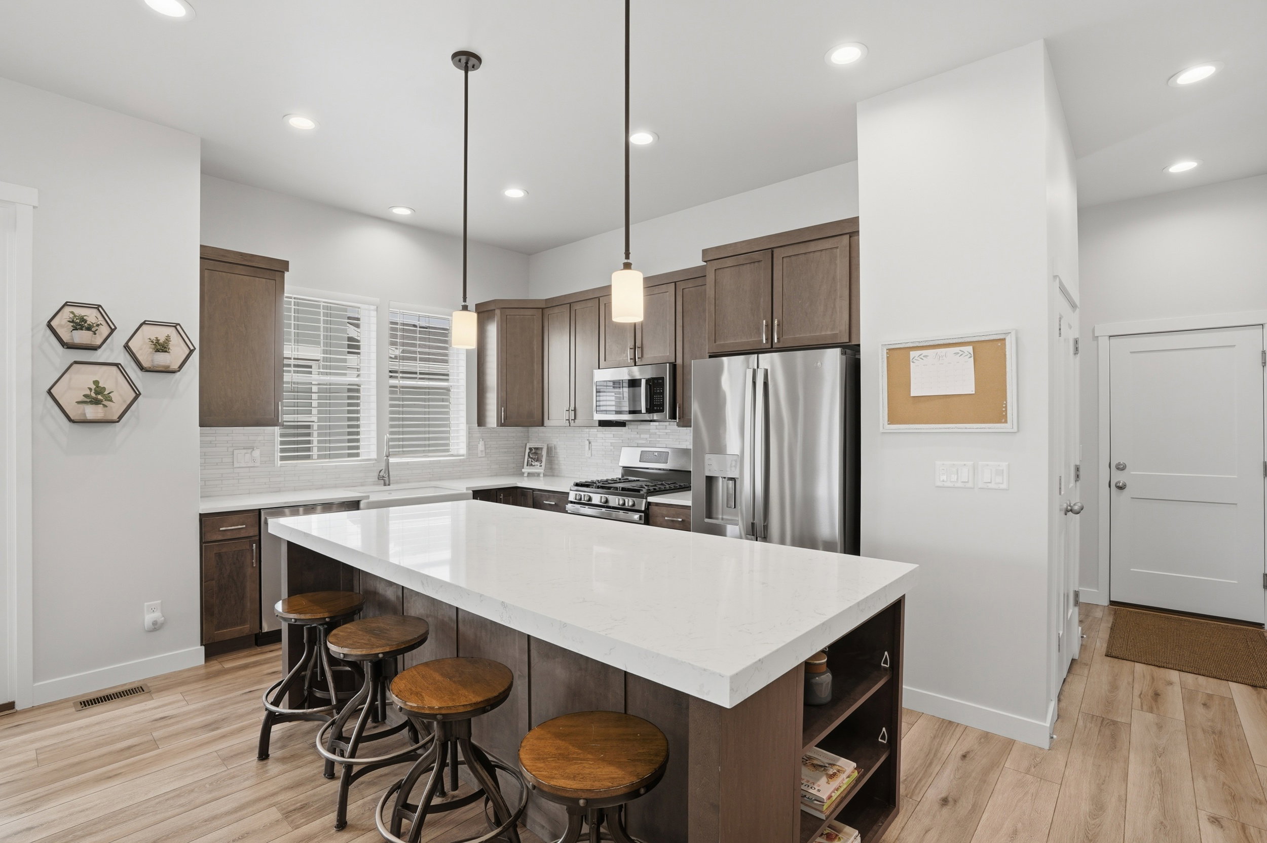 Kitchen with stainless steel appliances, light wood-style floors, a kitchen bar, and tasteful backsplash