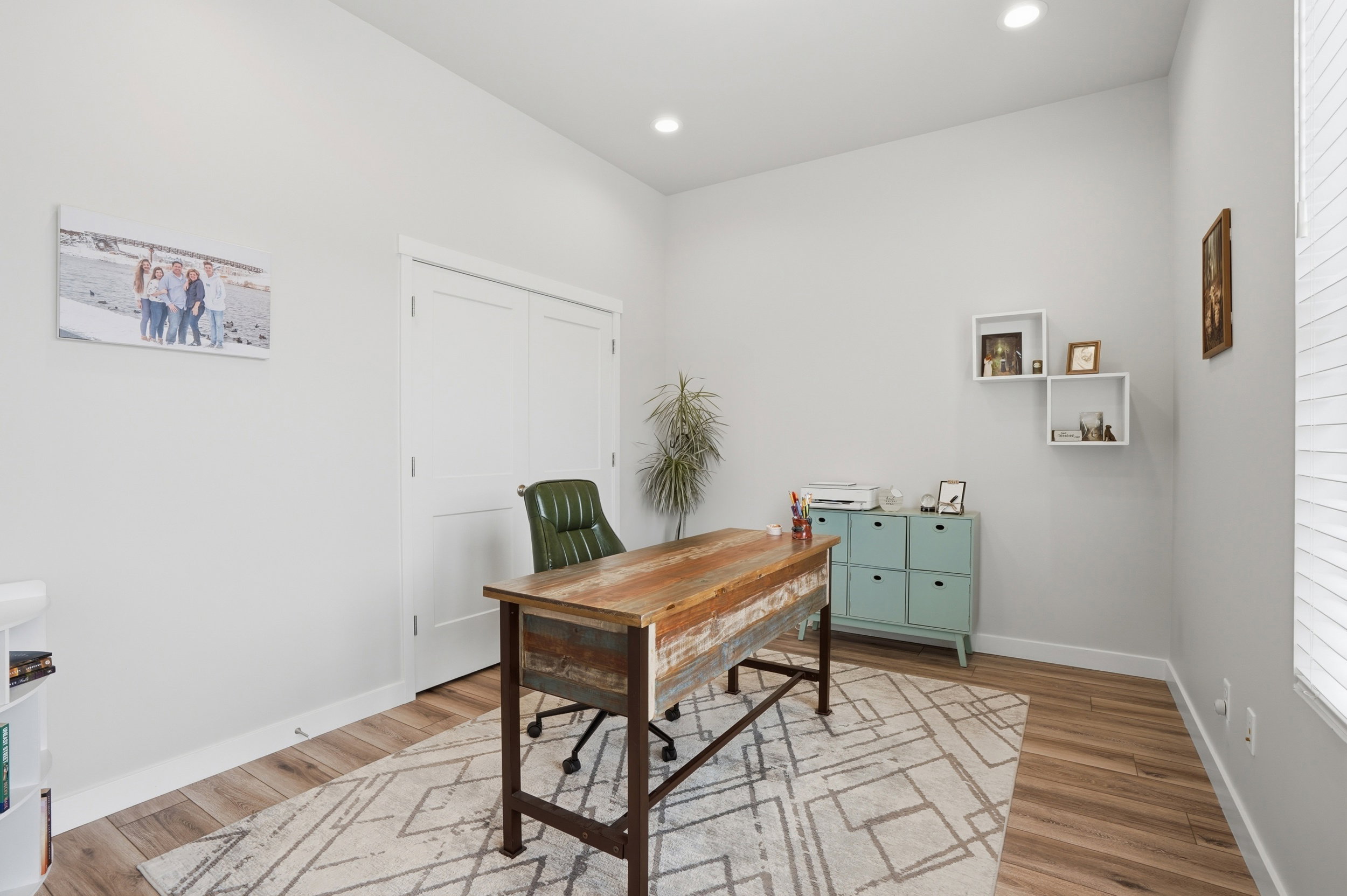 Office space with light wood-style floors and recessed lighting