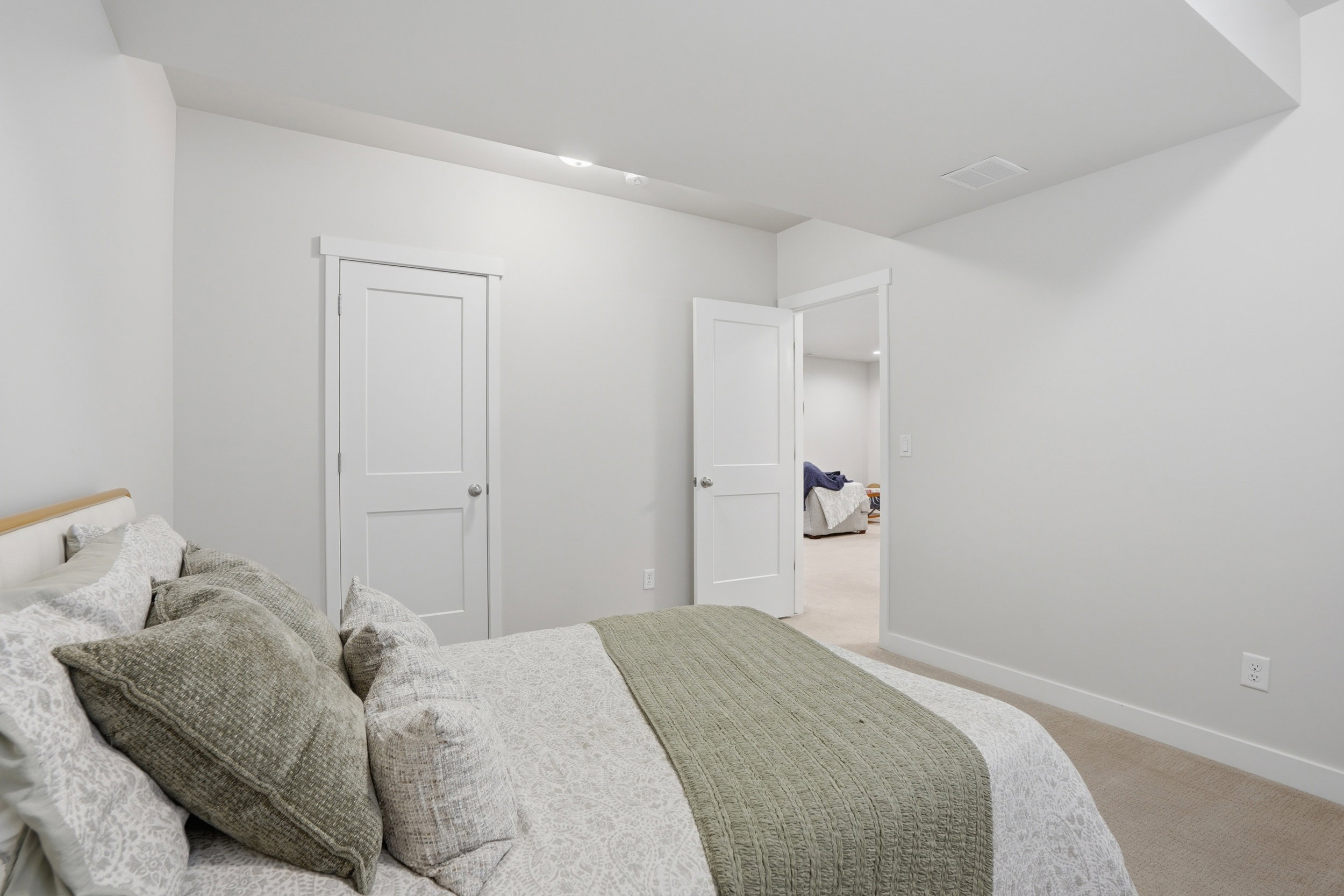 Bedroom featuring light carpet and baseboards