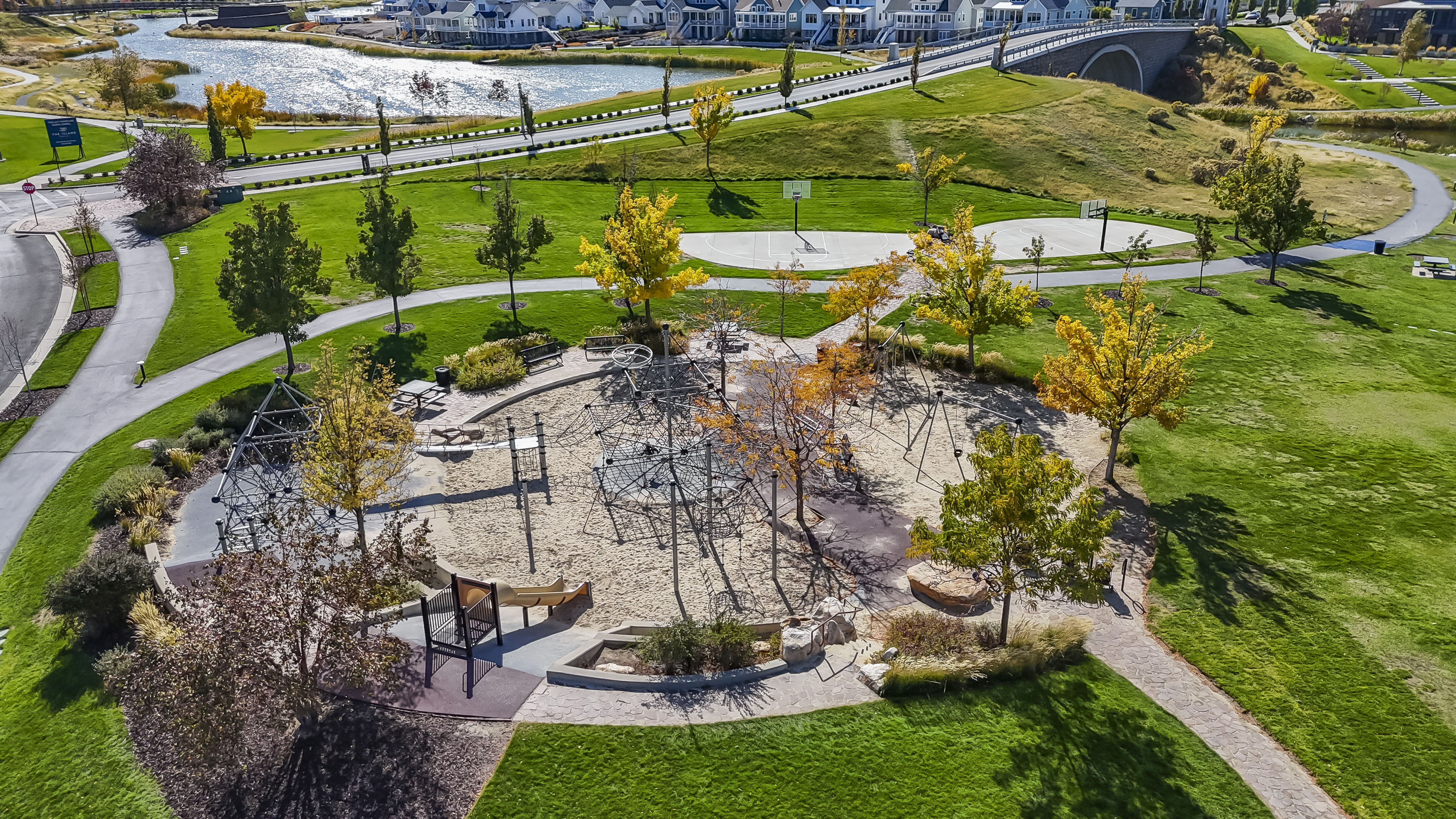 Aerial view of residential area featuring a nearby body of water and a park