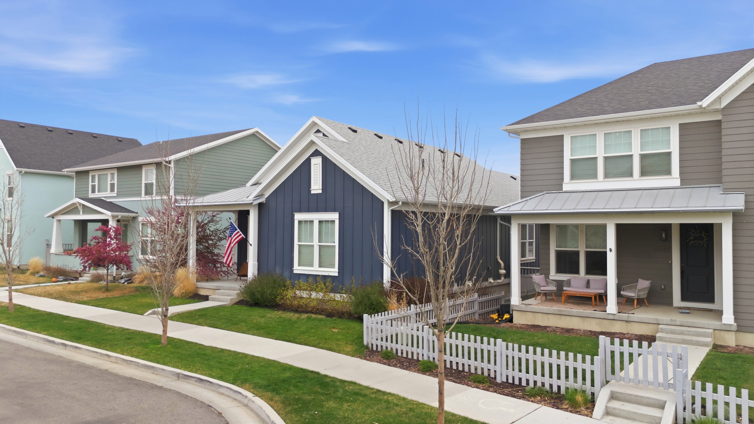 Traditional-style house with board and batten siding, a standing seam roof, a porch, and roof with shingles