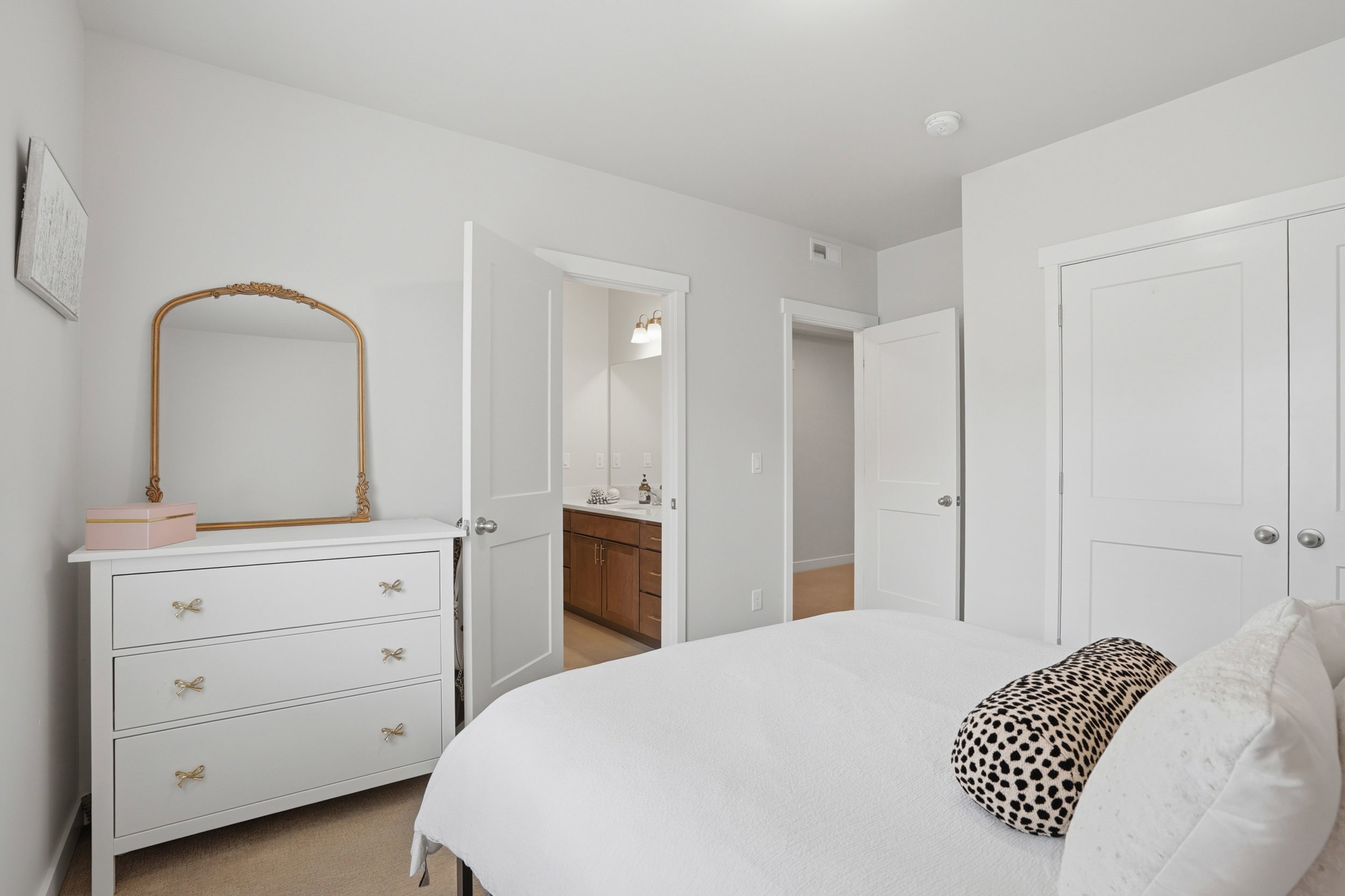 Bedroom with light colored carpet, a closet, and connected bathroom