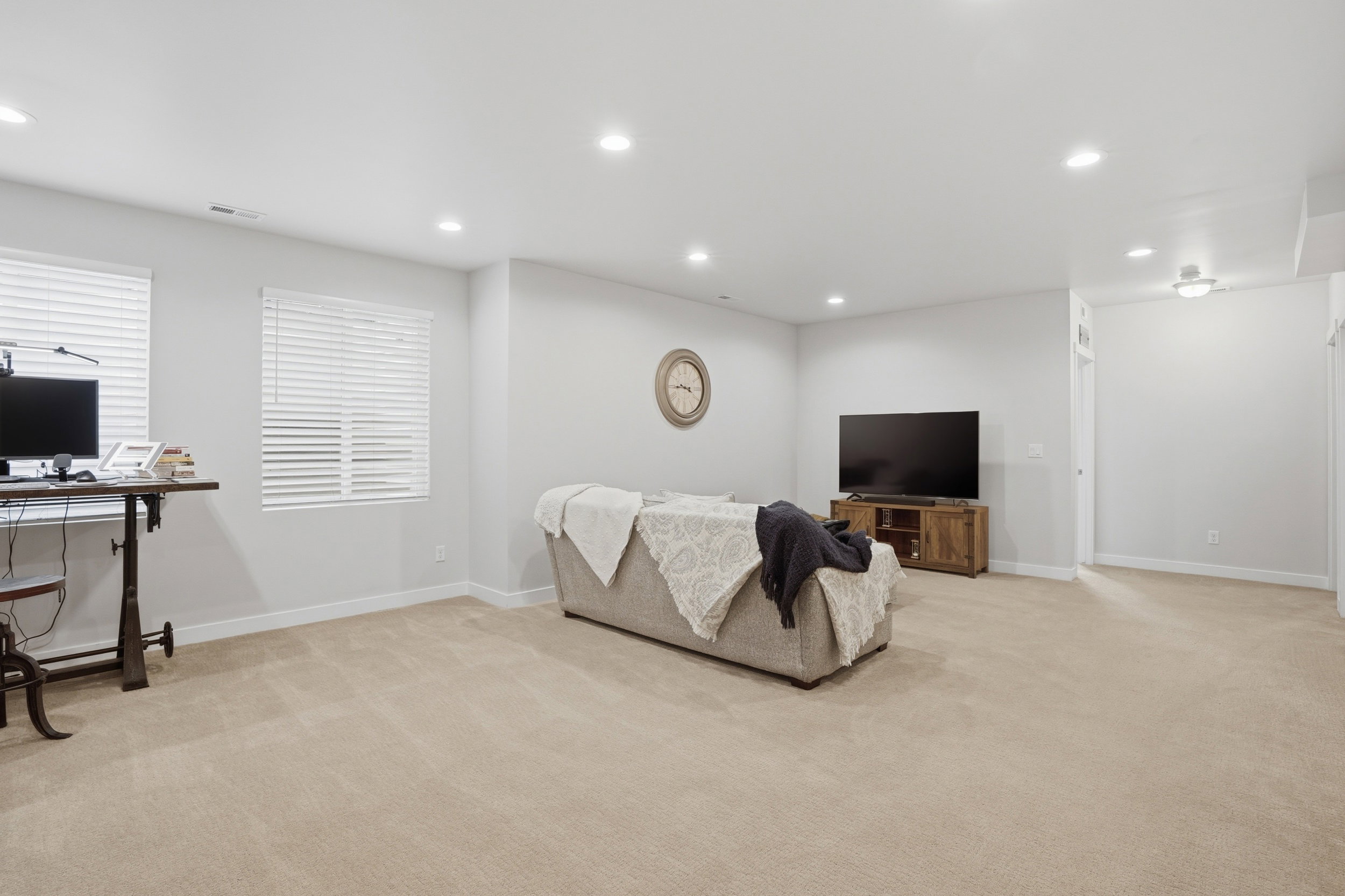 Living area with recessed lighting, light colored carpet, and an office area