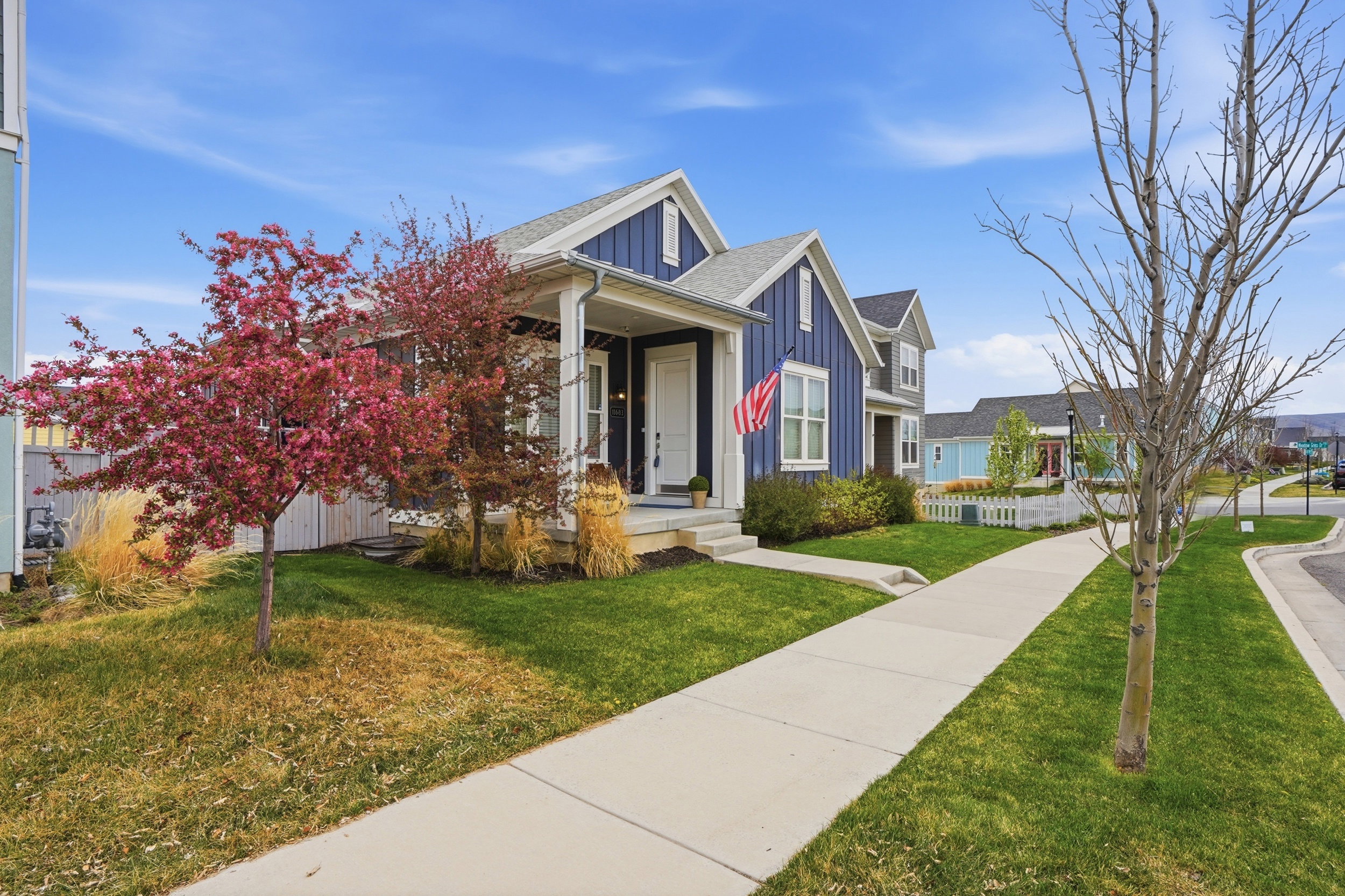 View of front of home featuring board and batten siding, a front yard, a shingled roof, and a porch