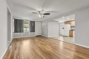 Unfurnished living room featuring light wood-style floors, a ceiling fan, and recessed lighting