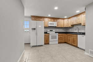 Kitchen featuring white appliances, recessed lighting, and light tile patterned floors