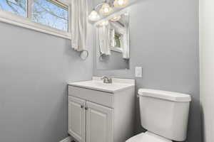 Half bathroom with healthy amount of natural light and vanity