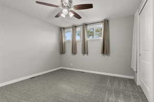 Spare room featuring carpet flooring and a ceiling fan