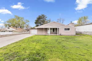 View of front of home with a garage, a chimney, a patio, and driveway