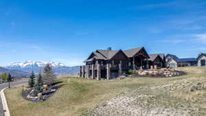View of front of house with a front lawn, a chimney, and a mountain view