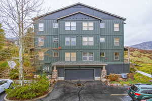 View of front of house featuring board and batten siding, a mountain view, and a garage