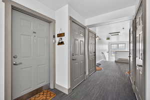 Hallway featuring dark colored carpet and an upstairs landing