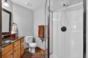 Full bath featuring a shower stall, vanity, and a textured ceiling