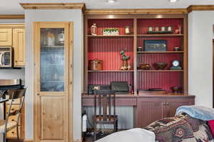 Bedroom featuring built in desk, crown molding, and a textured ceiling