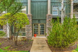 Doorway to property featuring french doors and stone siding