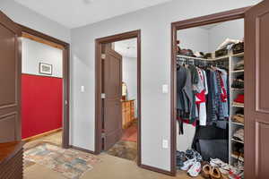 Bedroom with light colored carpet and a closet