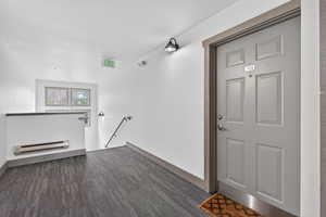 View of exterior entry with a baseboard heating unit