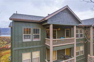 Rear view of house featuring a shingled roof, board and batten siding, and a balcony