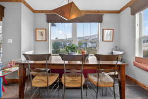 Dining room with crown molding, stone tile flooring, plenty of natural light, and a mountain view
