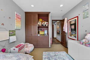 Bedroom with light carpet and recessed lighting