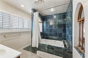 Bathroom featuring tiled shower / bath combo and vanity