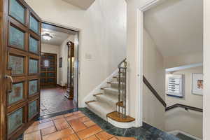 Foyer entrance with stairs and stone tile floors