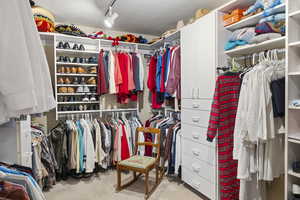 Walk in closet with light colored carpet