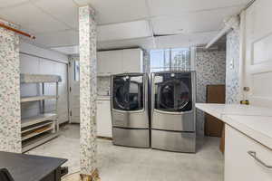 Laundry room with separate washer and dryer and cabinet space