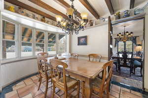 Dining room with suspended lighting and beam ceiling
