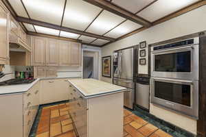 Kitchen with stainless steel appliances, a center island, and wood counters