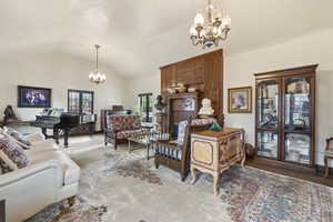 Living room featuring a chandelier, wood finished floors, and lofted ceiling