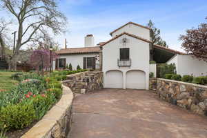Mediterranean / spanish home with a chimney, a garage, a tile roof, stucco siding, and concrete driveway
