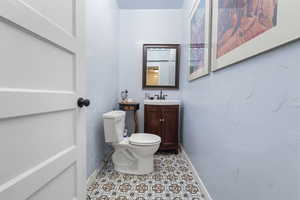Half bath featuring vanity and light tile patterned floors