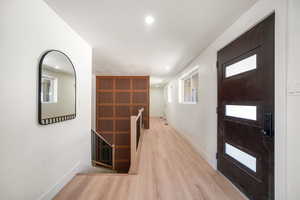 Foyer entrance with light wood-type flooring and recessed lighting