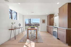 Dining area featuring wine cooler, light wood-type flooring, and recessed lighting