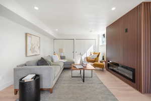 Living room with light wood-style flooring and recessed lighting