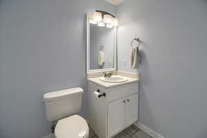 Half bath featuring vanity and light tile patterned flooring