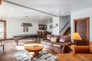 Living room with wood-type flooring, recessed lighting, and a community bar