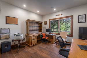Office area with dark wood finished floors and recessed lighting