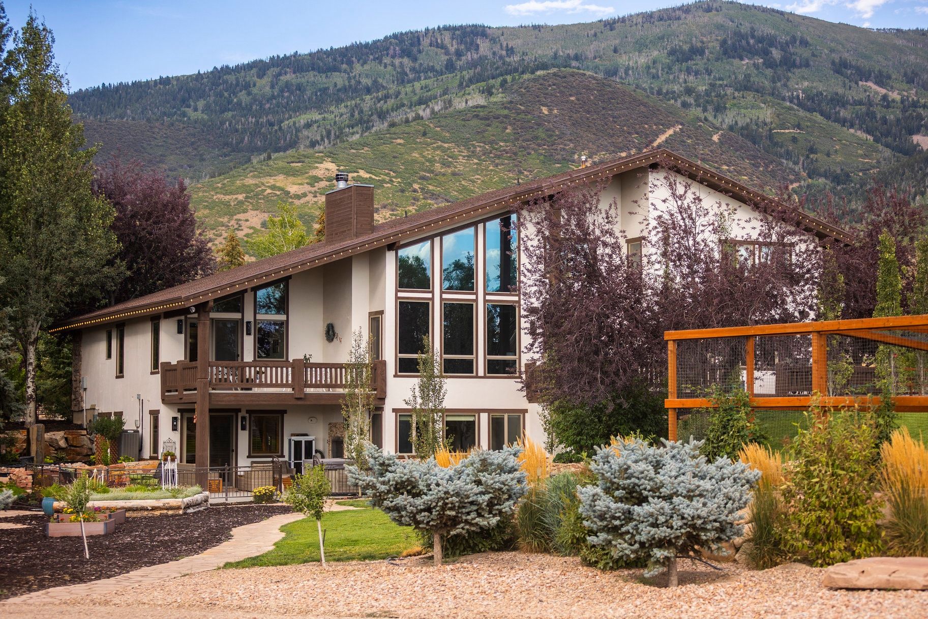 Rear view of property featuring a chimney, stucco siding, and a mountain view