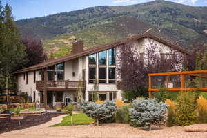 Rear view of property featuring a chimney, stucco siding, and a mountain view