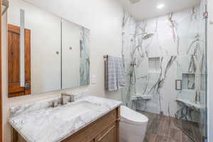 Full bath with vanity, a marble finish shower, recessed lighting, and wood finish floors