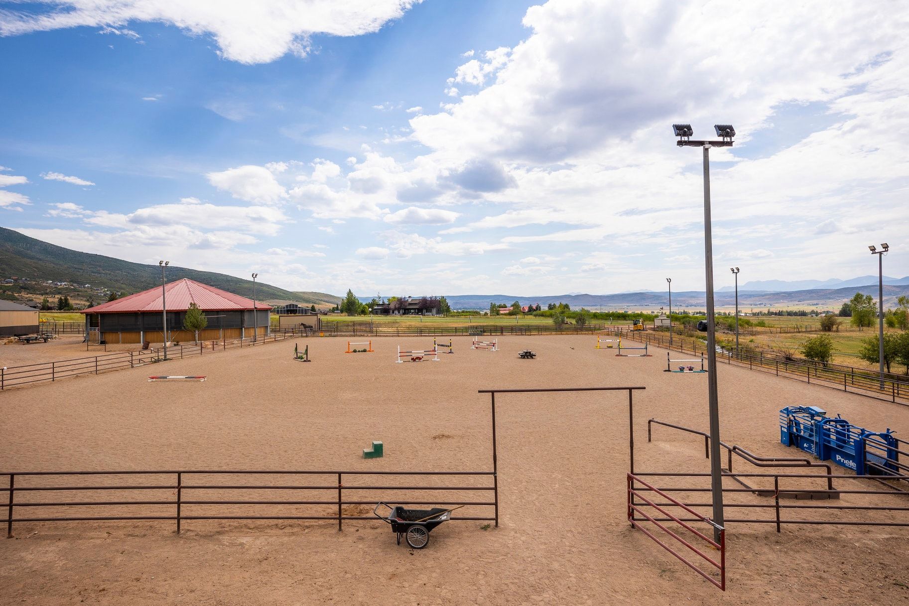 Surrounding community with an outdoor riding arena and a mountain view
