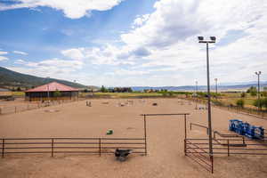 Surrounding community with an outdoor riding arena and a mountain view