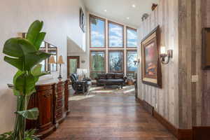 Corridor with a high ceiling, dark wood-style flooring, and recessed lighting