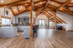 Kitchen featuring a peninsula, french doors, open floor plan, a high wood beamed ceiling, and open shelves